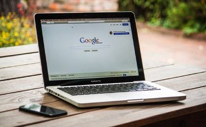 Pc con Google en la pantalla sobre mesa de madera